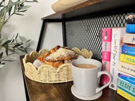 A kitchen with pastries and a cup of tea at Chapel Cottage Mevagissey