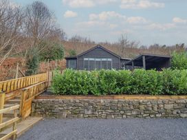 A cabin with a wooden fence and bushes at Lodge at Nadur