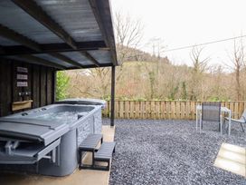 An outdoor area with a hot tub and seating at Lodge at Nadur Commins Coch near Machynlleth