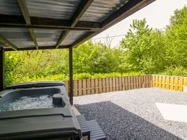 An outdoor area with a jacuzzi and gravel surface at Lodge at Nadur Commins Coch near Machynlleth