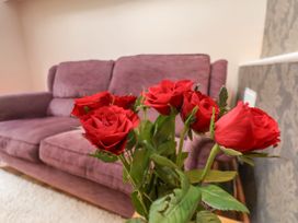 A living room with roses in a vase and a sofa at Sunnyvale House in Whitby