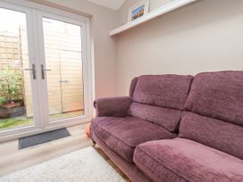 A living room with a sofa and double doors leading to the garden at Sunnyvale House in Whitby