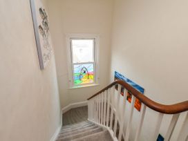 A staircase with artwork and a stained glass window at Sunnyvale House in Whitby