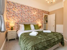 A bedroom with a bed and floral wallpaper at Sunnyvale House in Whitby