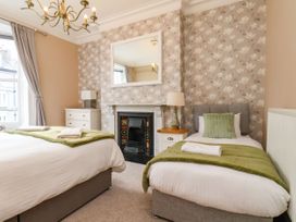 A bedroom with two beds and a fireplace at Sunnyvale House in Whitby