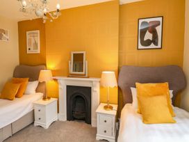 A bedroom with twin beds, nightstand, and fireplace at Sunnyvale House in Whitby