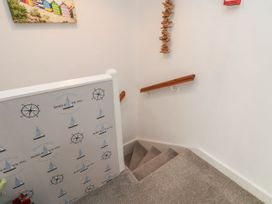A staircase with a handrail and wall art at Sunnyvale House in Whitby