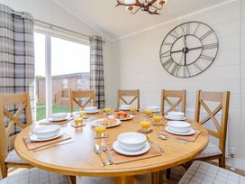 A dining room with a round table set for breakfast at The Folkesworth in Kings Cliffe