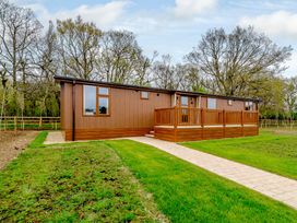 A log cabin with a deck and pathway at The Fotheringhay (Pet) in Kings Cliffe