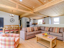 A living room with a dining area and kitchen at The Fotheringhay (Pet) in Kings Cliffe