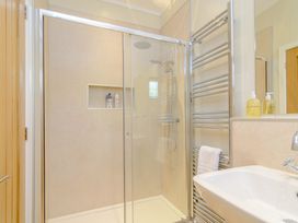 A shower with glass doors and a sink in the bathroom at The Fotheringhay (Pet) in Kings Cliffe