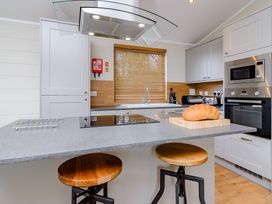 A kitchen with a kitchen island and stools at The Folkesworth (Pet) in Kings Cliffe