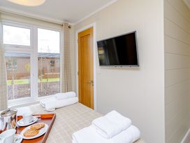 A bedroom with towels and tea set at The Alwalton (Pet) in Kings Cliffe