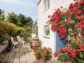 A garden with flowers and chairs at Bryn Tegid in Beaumaris