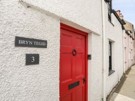 An exterior view of Bryn Tegid with a red door in Beaumaris