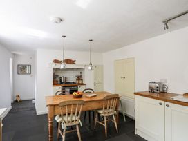 A kitchen with a wooden table and chairs at Bryn Tegid in Beaumaris
