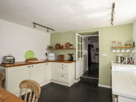 A kitchen with a counter, shelves, and appliances at Bryn Tegid Beaumaris