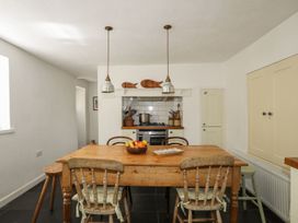 A kitchen with a wooden table and chairs at Bryn Tegid in Beaumaris