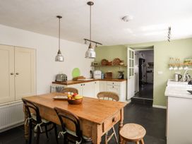 A kitchen with a wooden table and chairs at Bryn Tegid in Beaumaris