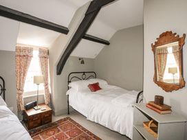 A bedroom with two beds and a nightstand at Bryn Tegid in Beaumaris