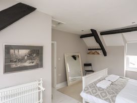 A bedroom with a bed and mirror at Bryn Tegid in Beaumaris