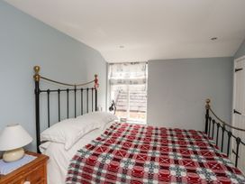 A bedroom with a bed and window at Bryn Tegid in Beaumaris