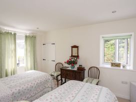 A bedroom with two beds and a table at Bryn Tegid Beaumaris