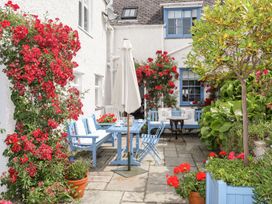 A garden with a table and chairs surrounded by flowers at Bryn Tegid in Beaumaris