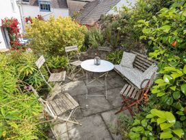 A garden with a table and chairs surrounded by plants at Bryn Tegid in Beaumaris