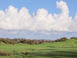 A golf course with grass and a flag at Bryn Tegid in Beaumaris