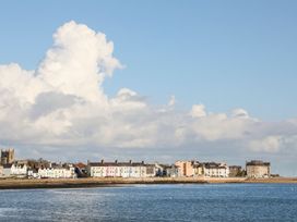 A coastal view with buildings and clouds at Bryn Tegid in Beaumaris