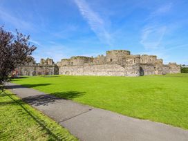 Castle ruins with grass and playground equipment in Beaumaris
