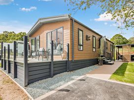 A house with a deck and chairs at Saron 2.0 Spa Pet in Llandyrnog
