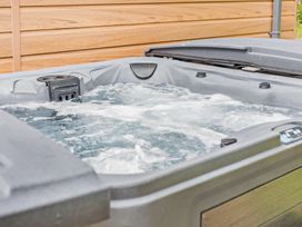 A hot tub with water and jets in an outdoor area at Saron 2.0 Spa Pet, Llandyrnog