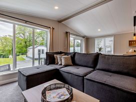 A living room with a sectional sofa and a coffee table at Saron 2.0 Spa Pet in Llandyrnog