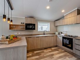 A kitchen with cabinets and appliances at Saron 2.0 Spa Pet in Llandyrnog