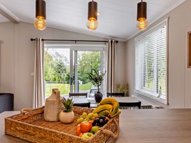 A dining room with a fruit basket and a sliding door at Saron 2.0 Spa Pet in Llandyrnog