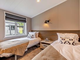 A bedroom with two beds and a window at Saron 2.0 Spa Pet in Llandyrnog