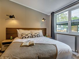 A bedroom with a bed and bedside tables at Saron 2.0 Spa Pet in Llandyrnog