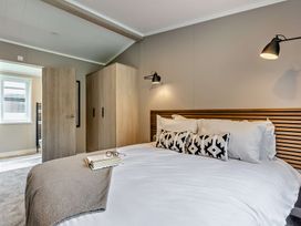 A bedroom with a bed and wardrobe at Saron 2.0 Spa Pet in Llandyrnog