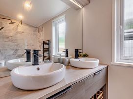 A bathroom with sinks and mirrors at Saron 2.0 Spa Pet in Llandyrnog