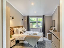 A bedroom with a bed and bedside table at Saron 2.0 Spa Pet in Llandyrnog