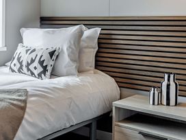 A bedroom with a bed and nightstand at Saron 2.0 Pet in Llandyrnog