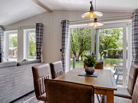 A dining room with a table and chairs overlooking a garden at Saron 2.0 Pet in Llandyrnog