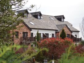 A building with a balcony and trees at Fell View Apartment in Penrith