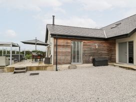 An outdoor area with a house, patio set, and gravel at Cae Sam Pentraeth