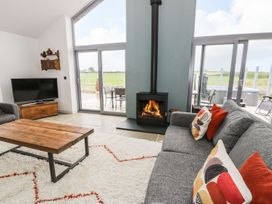 A living room with a fireplace and television at Cae Sam in Pentraeth