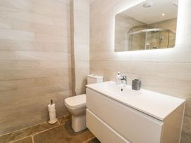 A bathroom featuring a toilet, sink, and shower at Cae Sam in Pentraeth