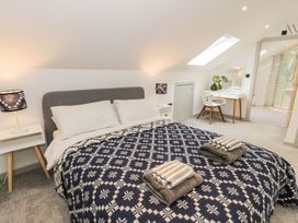 A bedroom with a bed and desk at Cae Sam Pentraeth