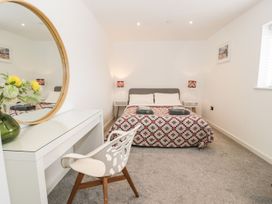A bedroom with a bed and desk at Cae Sam in Pentraeth